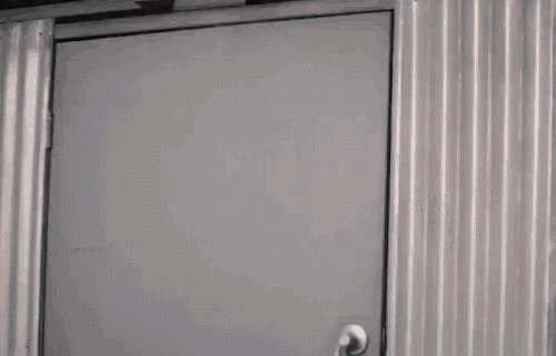 a man is standing in a doorway looking out of it .