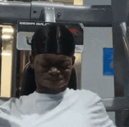 a man in a white shirt is using a machine in a gym