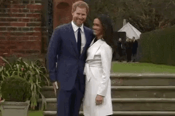 a man in a suit and tie and a woman in a white dress are standing next to each other .