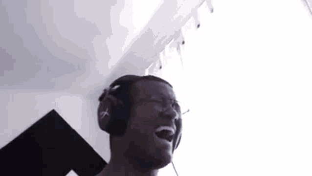 a man wearing headphones is singing into the microphone .