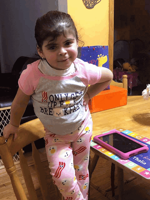 a little girl wears a shirt that says only get up for breakfast