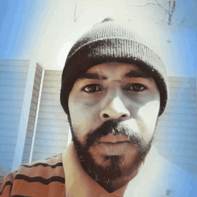 a man with a beard is wearing a beanie