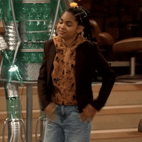 a girl wearing a brown jacket and jeans is dancing