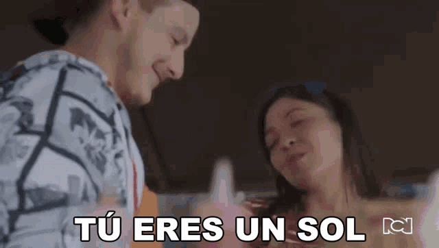 a man and a woman are standing next to each other with the words tu eres un sol in the corner