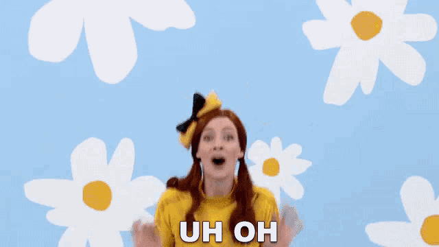 a woman in a yellow outfit is standing in front of daisies and says uh oh .