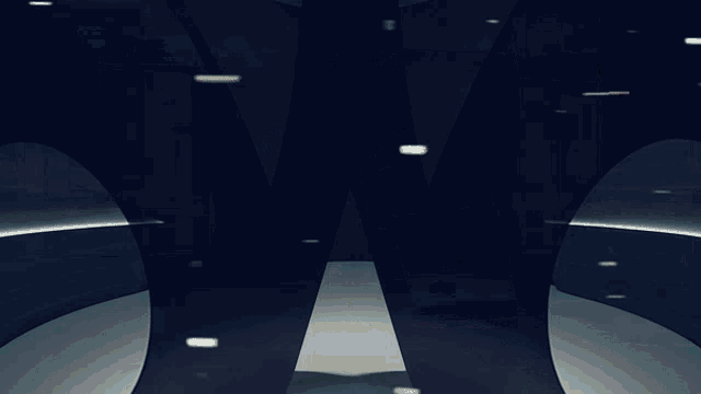 a large black letter w is in the middle of a room with columns