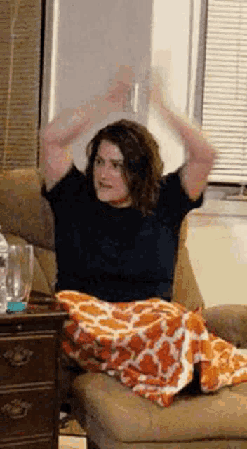a woman is sitting in a chair with her arms up