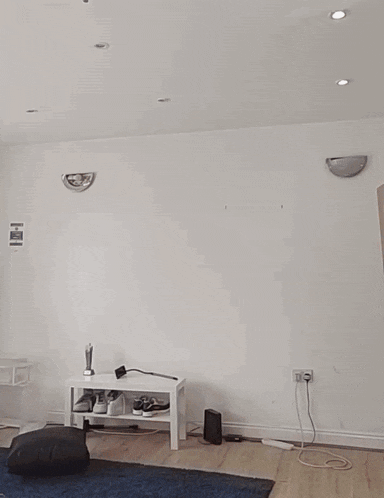 a man without a shirt is riding a skateboard in a room