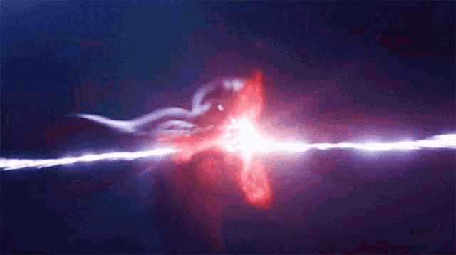 a person is holding a purple object in their hand in a dark room .