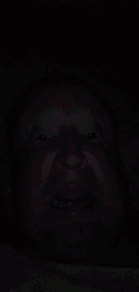 a close up of a man 's face in the dark with his eyes closed