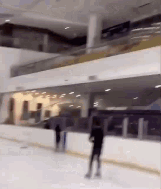 a person is skating on an ice rink in a large building