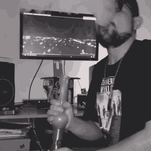 a man smoking a bong with a shirt that says zombies world