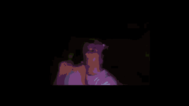 a man wearing headphones and a hat is giving the middle finger in a dark room .