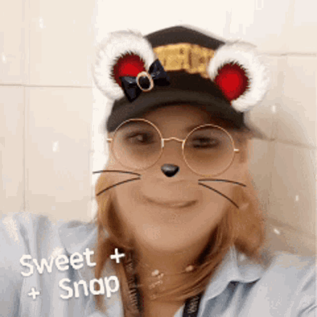 a woman wearing a hat and glasses with a sweet snap sticker on her face