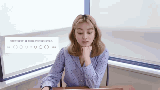 a woman sits at a desk in front of a sign that says ' circles '