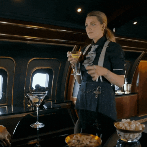 a woman holds a martini in her hand in a room