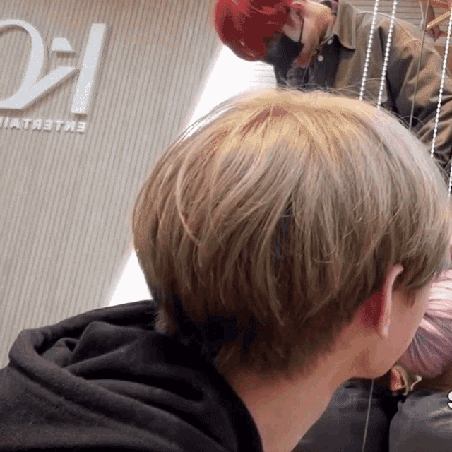 a close up of a person 's hair in front of a sign that says ' oi '