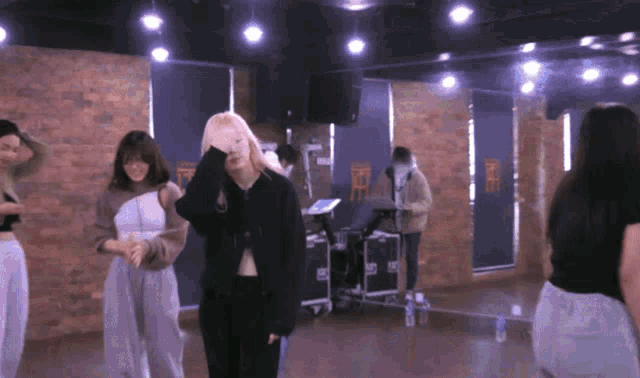 a group of women are dancing in a room with a sign on the wall that says ' nct ' on it