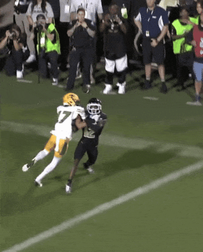 a football player with the number 7 on his jersey is trying to tackle another player