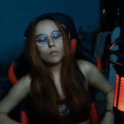 a woman wearing glasses is sitting in front of a microphone in a chair .