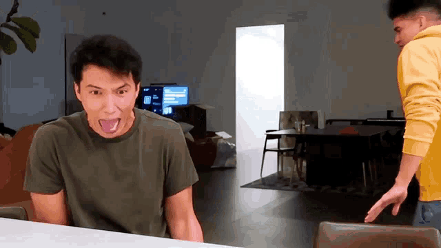a man sticking his tongue out in front of a tv