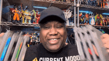 a man wearing a current mood t-shirt is smiling