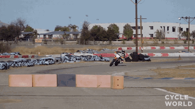 a person riding a motorcycle on a track that says cycle world on it