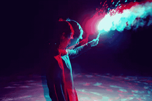 a man is holding a red and blue torch in the dark
