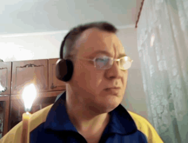a man wearing glasses and headphones is holding a lit candle