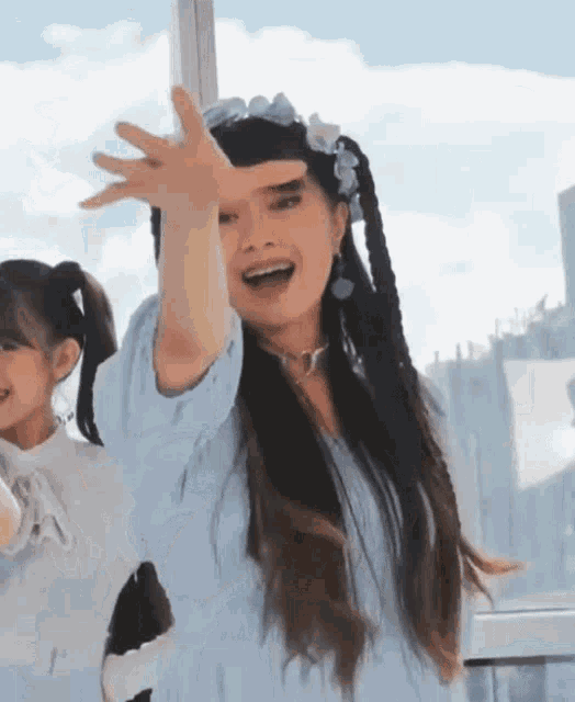 a woman with pigtails is making a funny face with her hand in the air