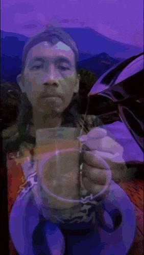 a painting of a man holding a cup of coffee with a mountain in the background
