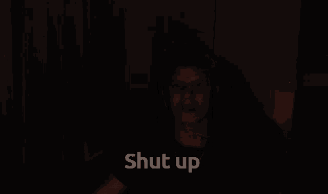 a man is screaming in the dark with the words shut up written below him