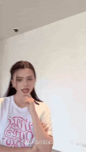 a woman wearing a white t-shirt that says " hooduseries " on it