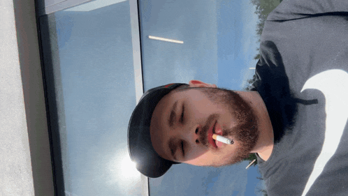 a man smoking a cigarette with his eyes closed