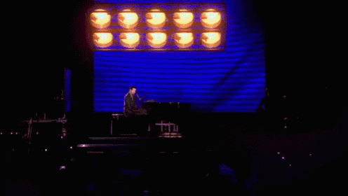 two candles are lit up in the dark with a blue background