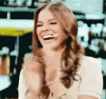 a woman is laughing while wearing a microphone