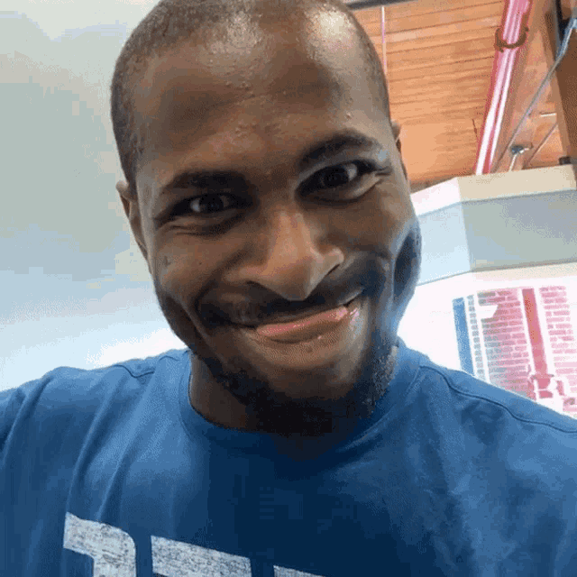 a man wearing a blue t-shirt with the letter t on it