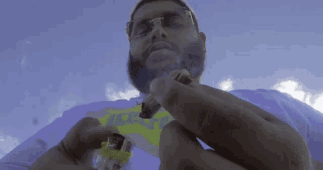 a man with a beard is smoking a cigarette with a lighter in his hand .
