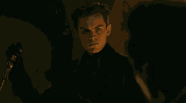 a man in a suit is holding a cane in his hand and looking at another man .