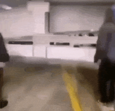 a blurry picture of a person walking down a sidewalk in a parking garage .