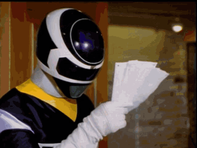 a black and white ranger is holding a piece of paper