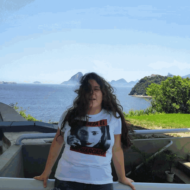 a woman wearing a white t-shirt that says " pizza el "
