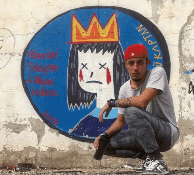 a man kneeling in front of a painting of a girl with a crown