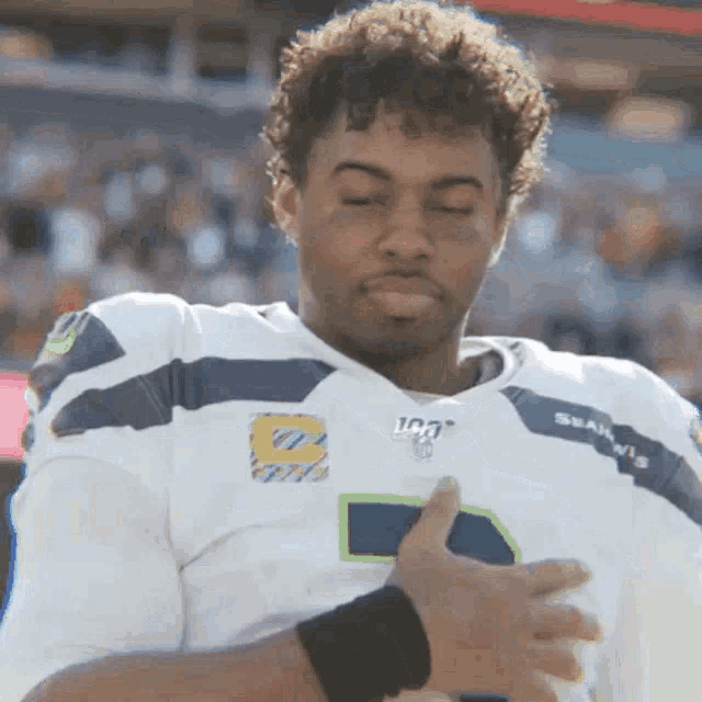a man wearing a seahawks jersey with the number 8 on it