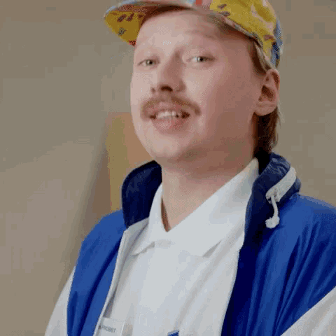 a man wearing a blue jacket and a yellow hat has a name tag that says ' christ '