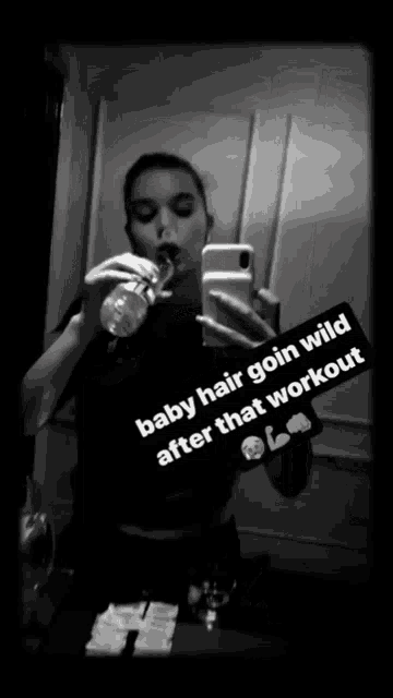 a black and white photo of a woman drinking water and taking a selfie