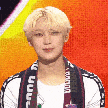 a young man with blonde hair is wearing a scarf around his neck that says ' mexico ' on it .