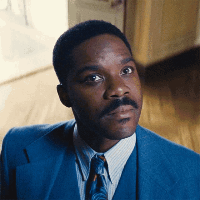 a man in a blue suit and tie is looking up