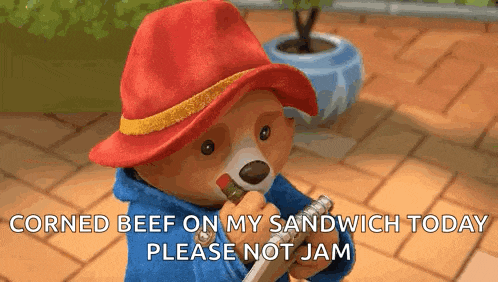 paddington bear eating corned beef on a sandwich today please not jam