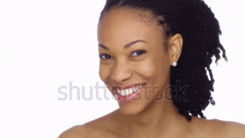 a woman without a shirt is smiling in front of a white background